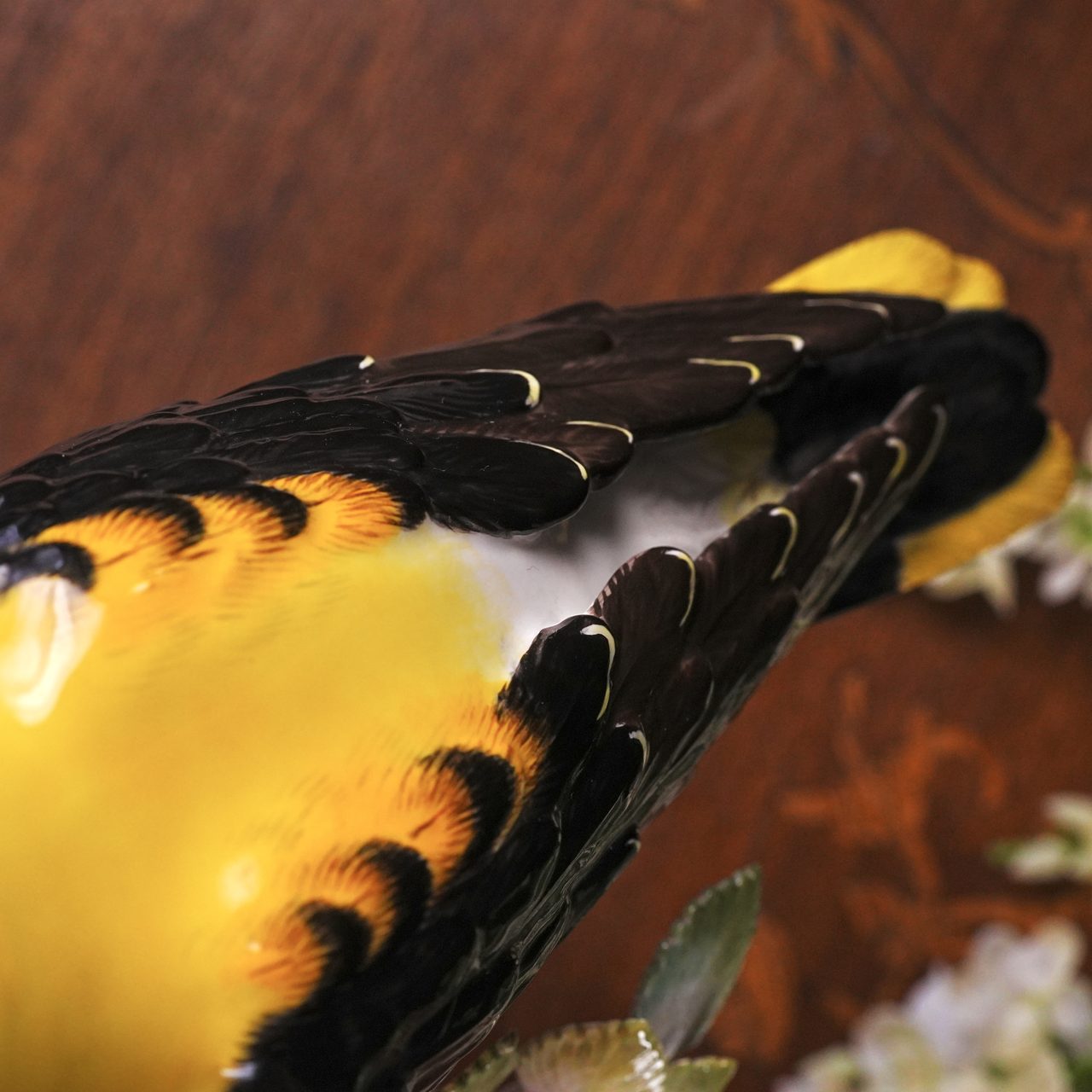 Close detail of the Meissen Golden Oriole's back and folded wings — black flight feathers barred with amber and gold over a golden-yellow back
